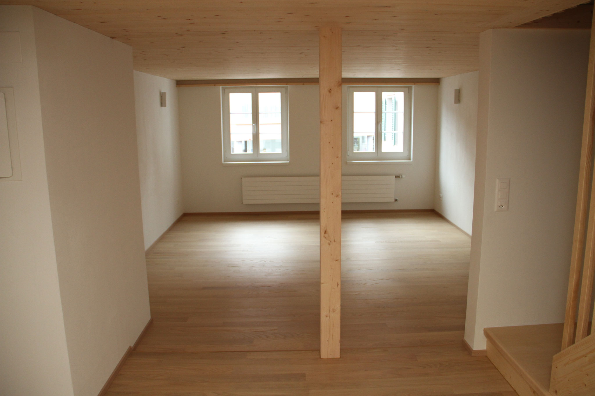 Heller Wohnraum mit Eichenboden und sichtbarer Holzdecke