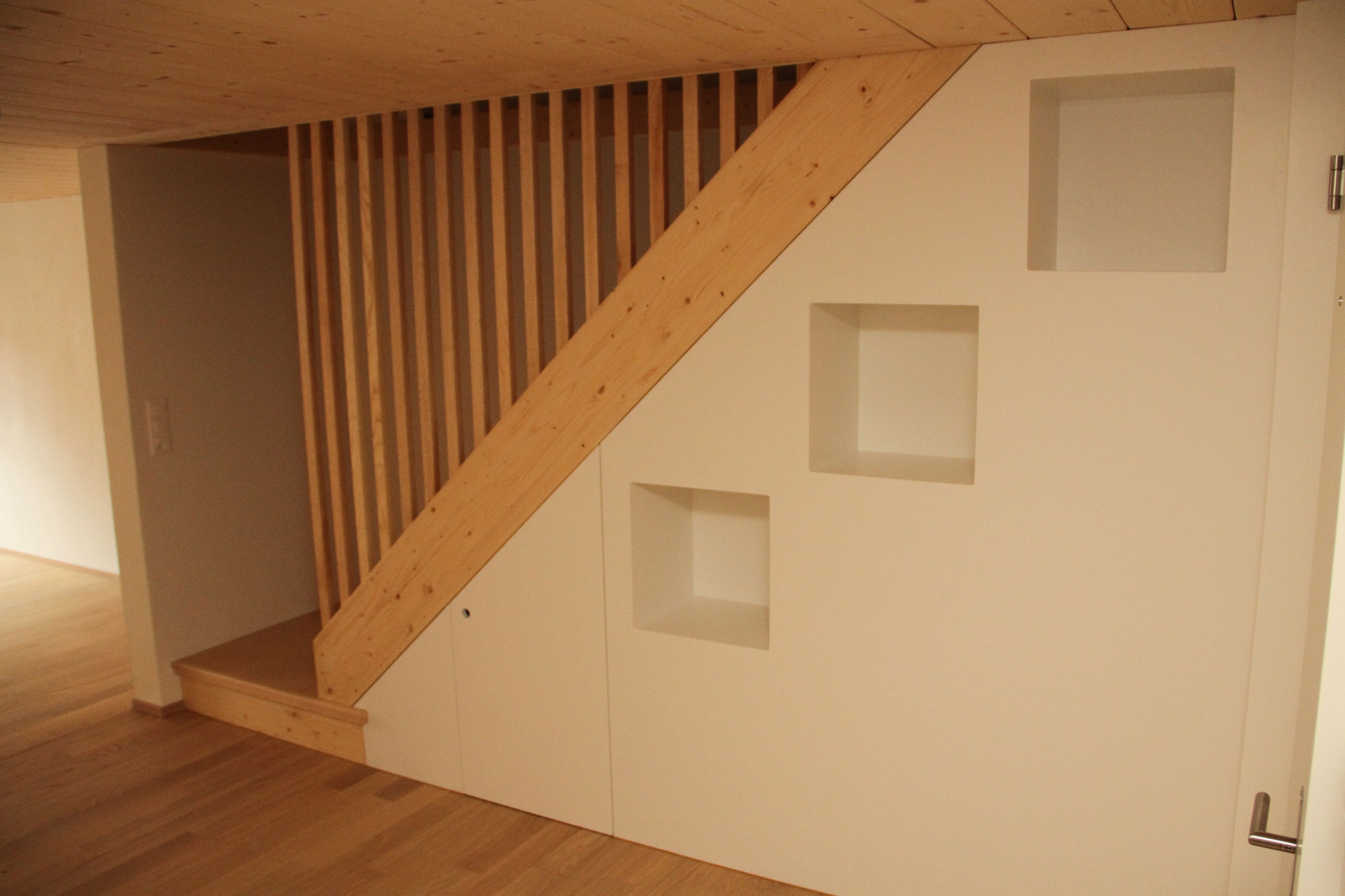 Treppe mit feiner Holz-Lamellenwand und eingelassenen Nischen